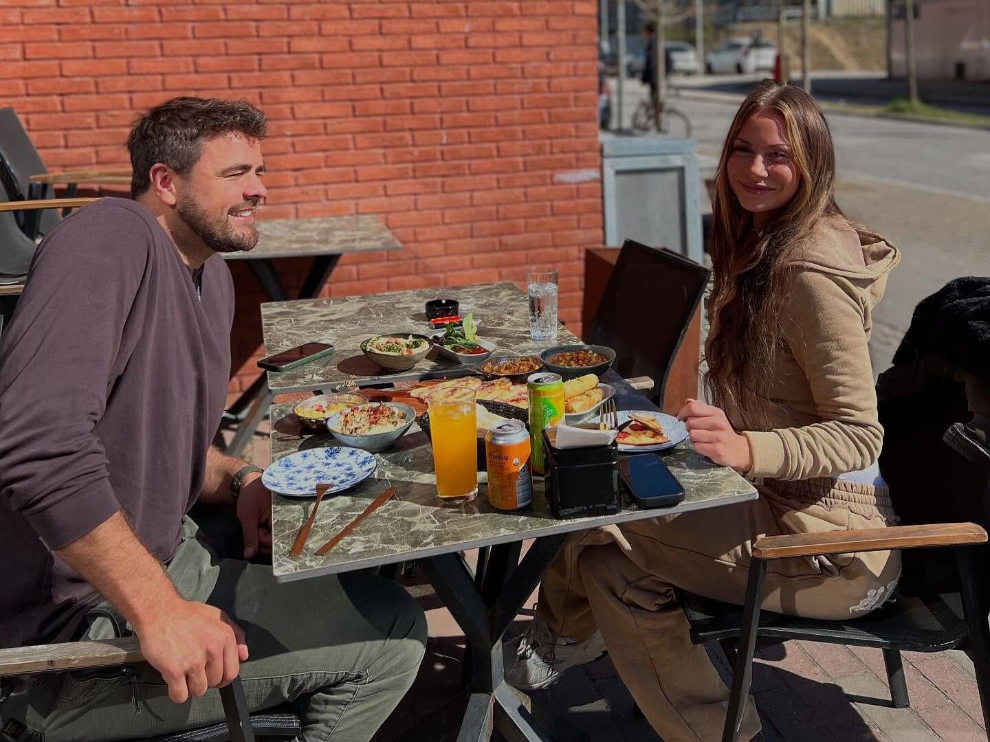Glade gæster nyder frokost på Zyaras terrasse i solen